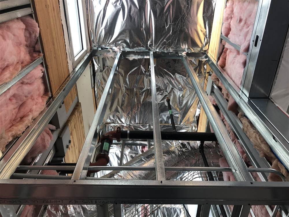 Metal stud framing with insulation, looking up